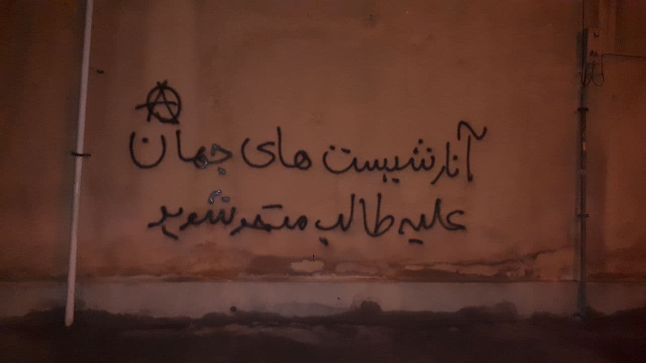 A wall graffiti saying "Anarchists of the world unite against Taliban"